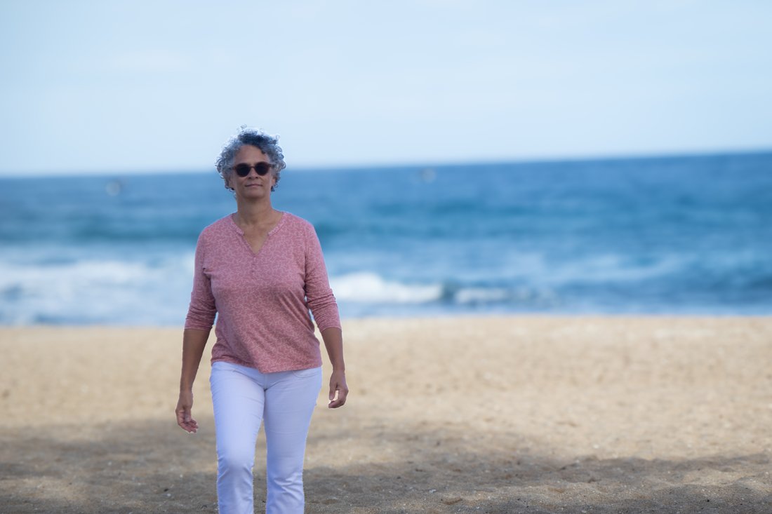 Valérie Patole marchant sur la plage de Boucan Canot, face à l'océan, à deux pas de son cabinet